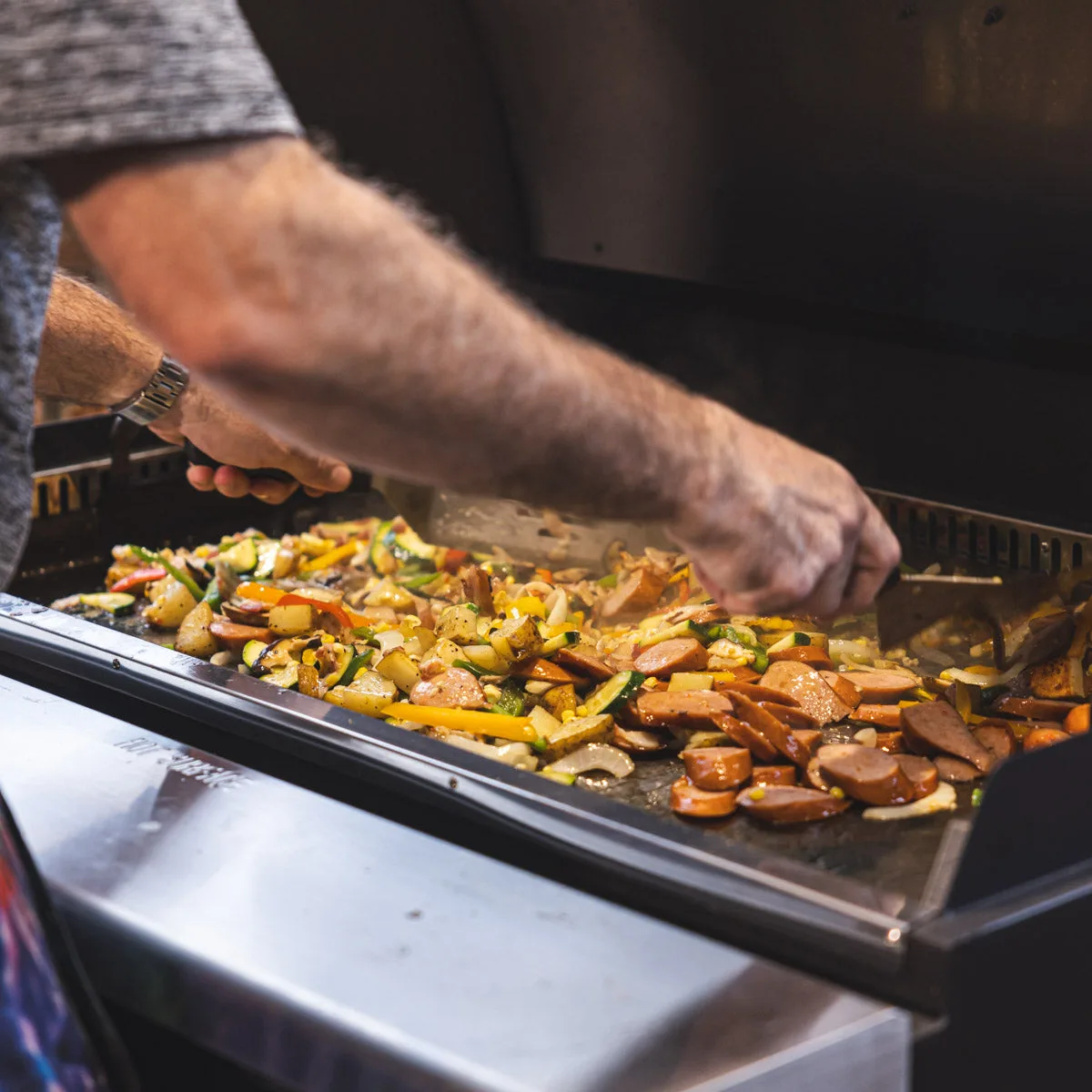 Peppers, onions, and sausage on a SmokeStone griddle